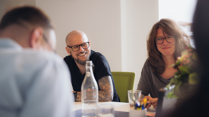 Plan2net Team sitzt am Besprechungstisch im Büro