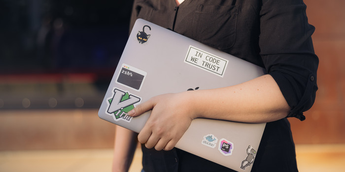 Junge Frau hält Laptop unter dem Arm